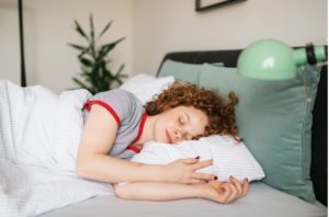 young redhead woman sleeping after recovering from anxiety night sweating