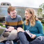 Man and Woman researching outside on the lawn.