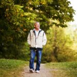 Happy senior man walking and relaxing in park