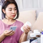 Woman reading the package insert of her medication to see if taking Zoloft® make her gain weight?