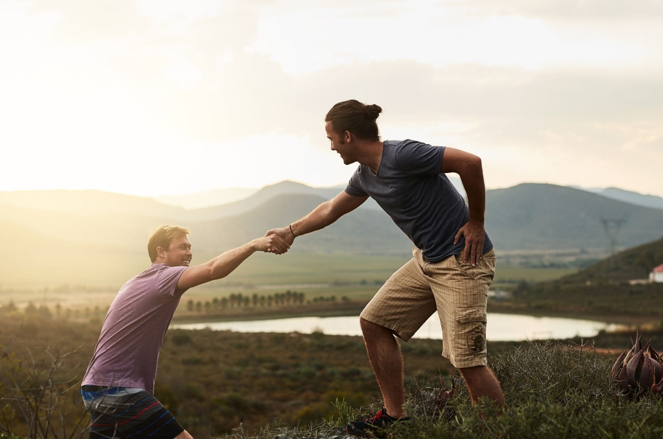 young man assisting another man up representing helping someone with depression