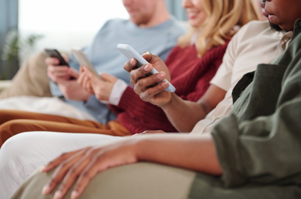 group of people on smartphones to show pros and cons of social media on mental healtg