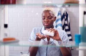 young woman taking anti depression meds in medicine cabinet
