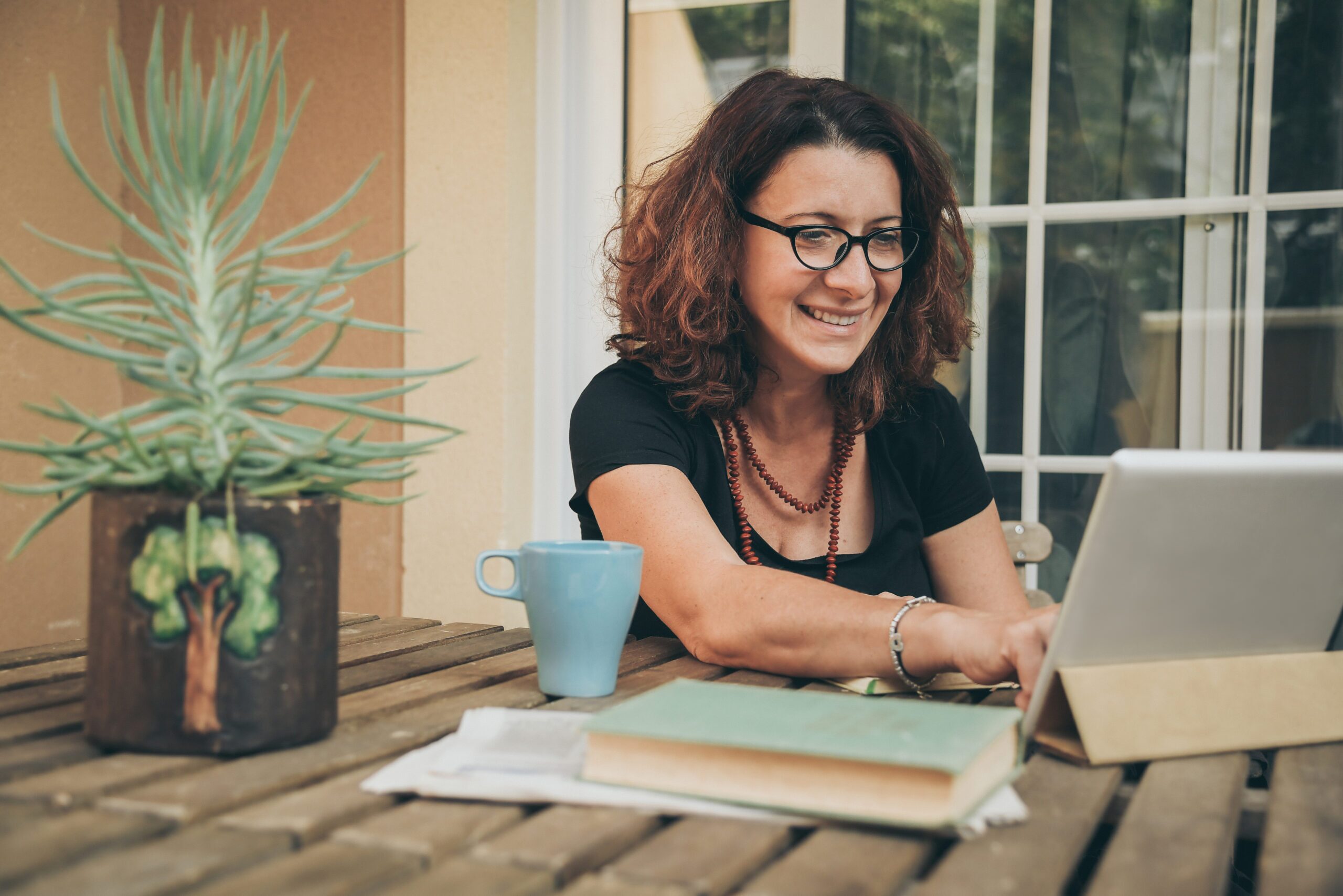 Middle aged female researching at home on her computer.