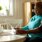 A woman at home taking her blood pressure, emphasizing the importance of monitoring other health conditions, like high blood pressure, before starting Ozempic® to ensure safe and effective treatment.